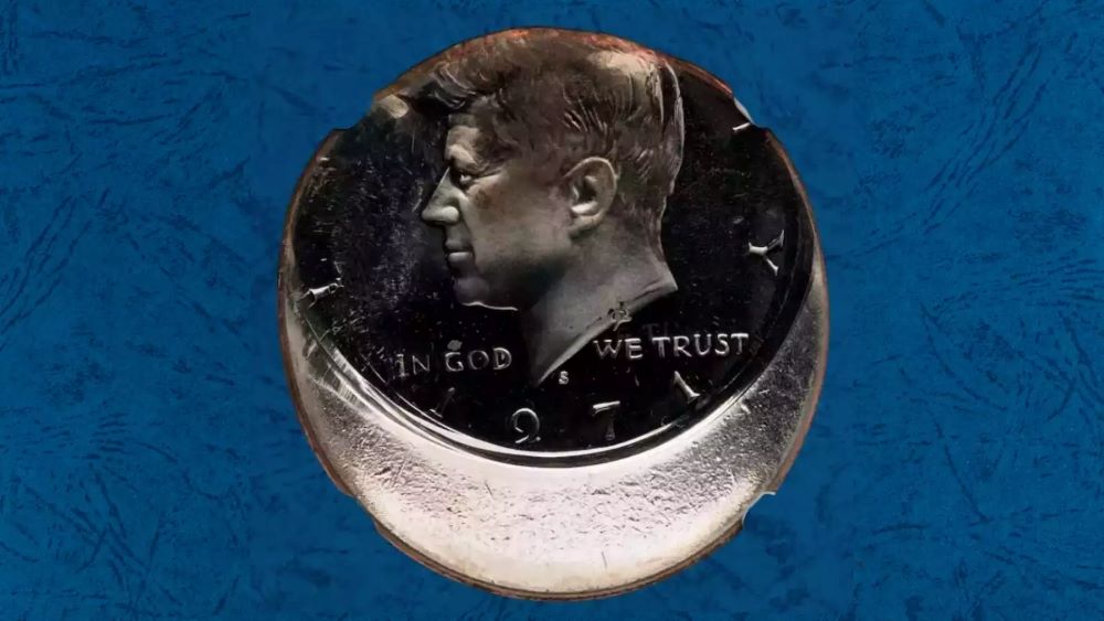1971 Kennedy Half Dollar off-center strike error — JFK portrait shifted with blank metallic crescent on opposite side, date 1971 readable — a visually dramatic mint error